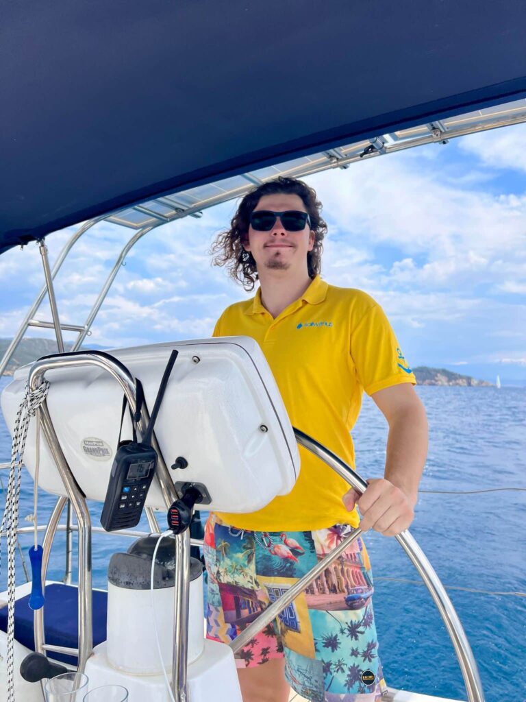 Skipper Dankrad steuert ein Segelboot im Sailwithus-T-Shirt