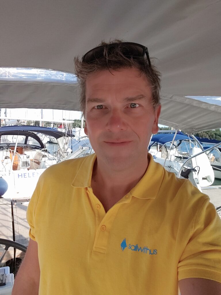 Skipper Heiko steuert ein Segelboot im Sailwithus-T-Shirt