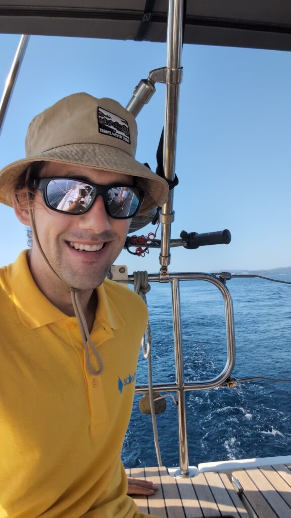 Skipper Jonas steuert ein Segelboot im Sailwithus-T-Shirt