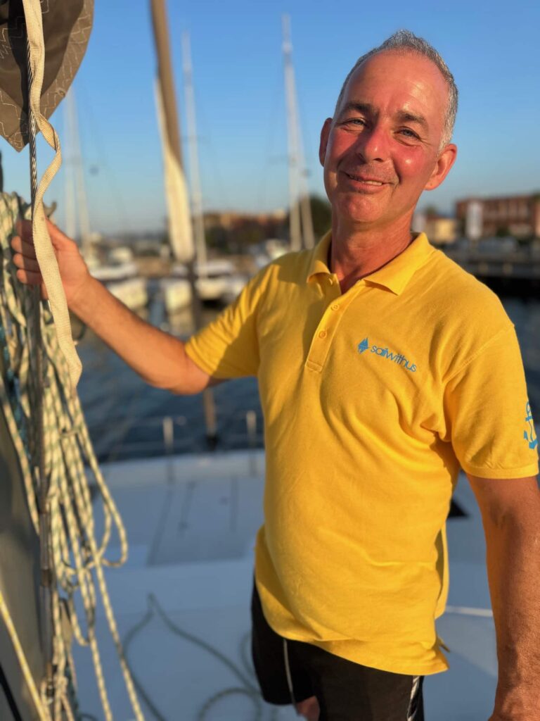 Skipper Frank steuert ein Segelboot im Sailwithus-T-Shirt
