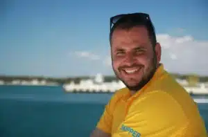 Skipper Jürgen steuert ein Segelboot im Sailwithus-T-Shirt